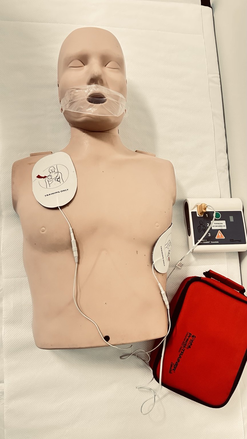 AED trainer connected to pads on manikin